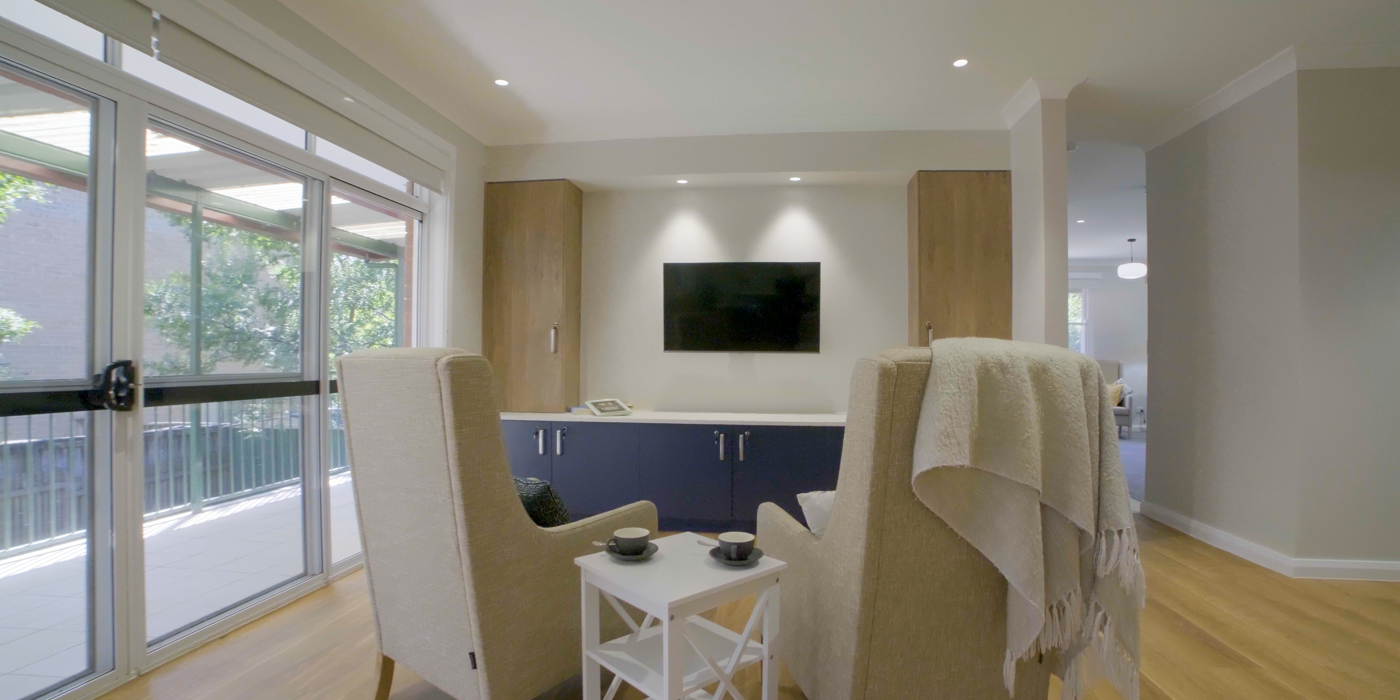 Cozy living room with a wall-mounted TV and a comfortable sofa