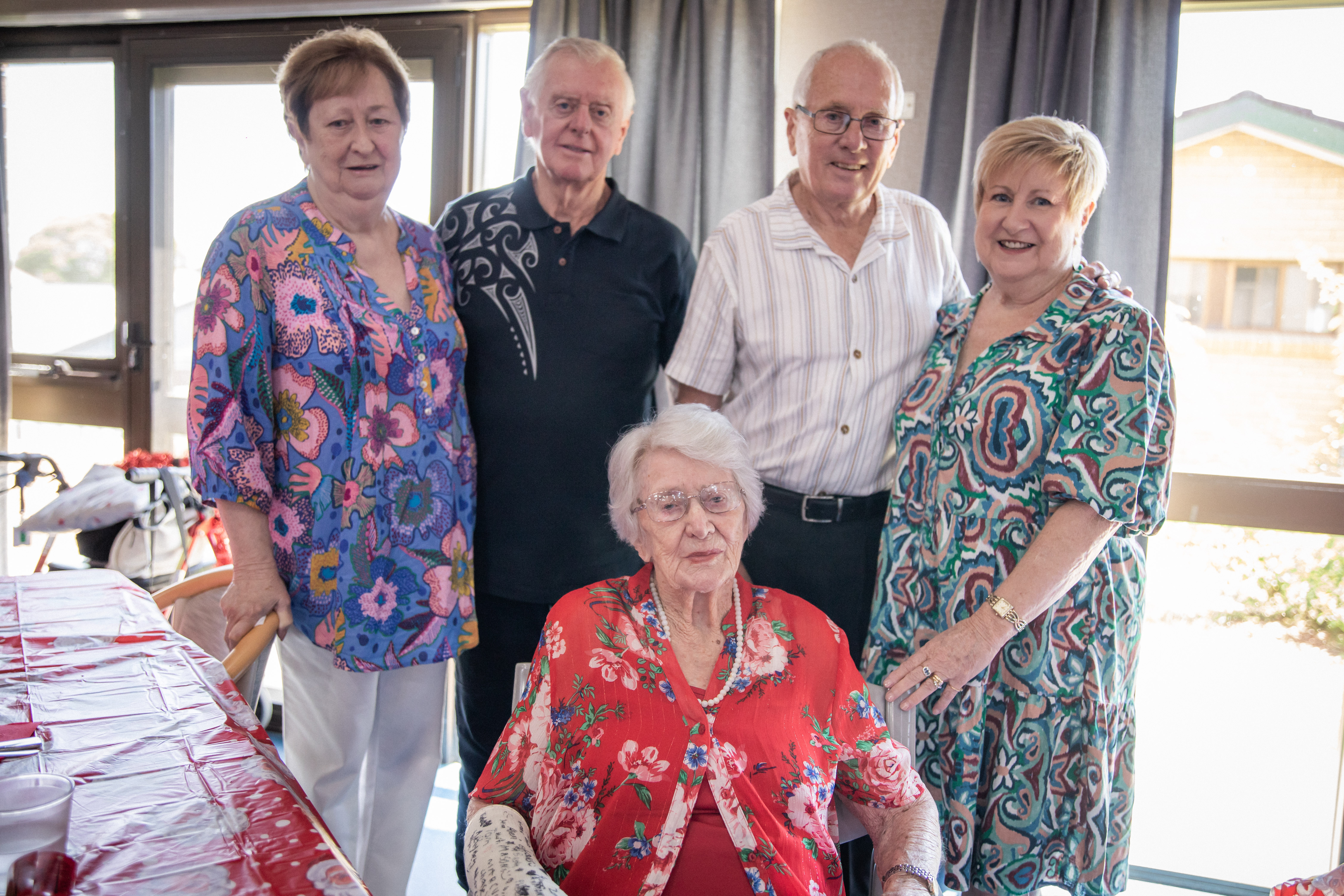 A senior resident, her family, and a caring staff member